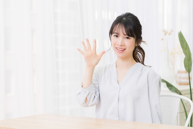 片手で５を示す笑顔の女性.jpg