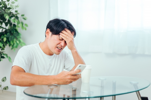 スマホ見てショックを受ける男.jpg