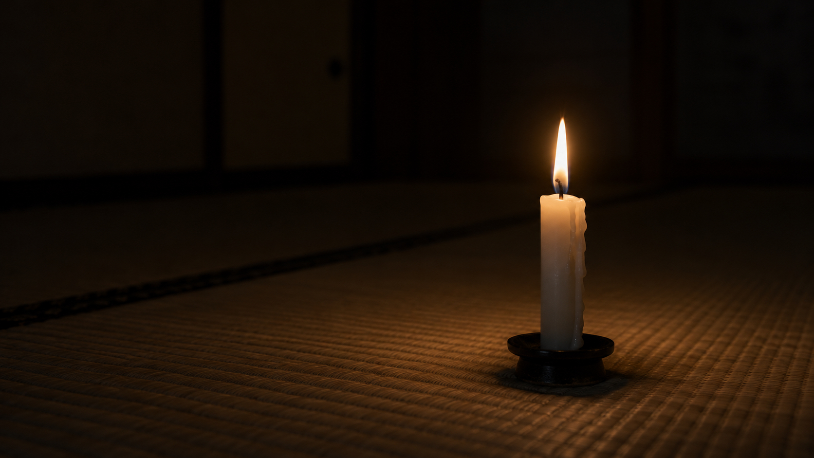 暗闇に灯る和室の蝋燭.png
