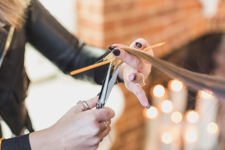woman-stylist-cuts-hair-at-salon.jpg