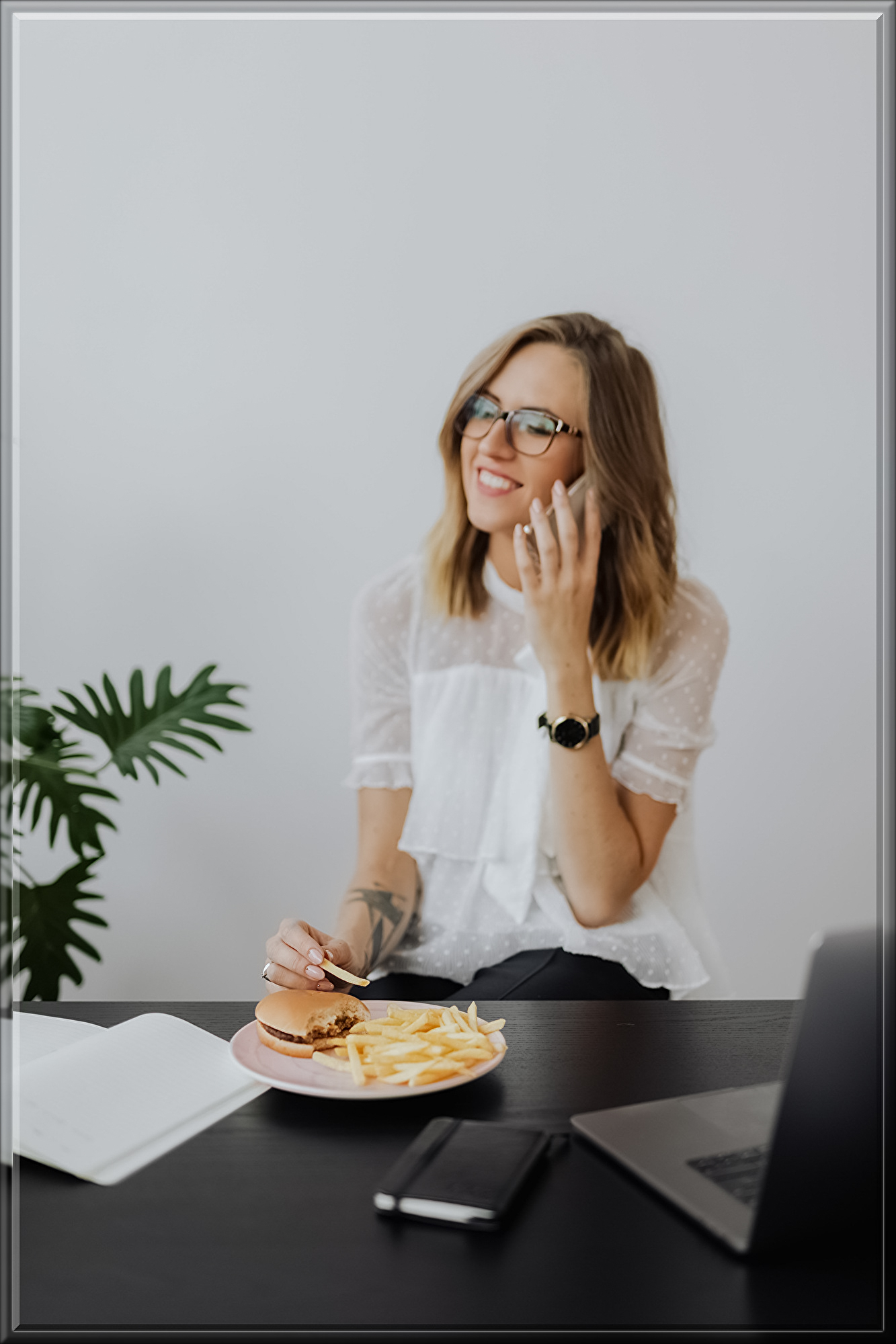 kaboompics_Businesswoman eats at work hamburger and fries.jpg